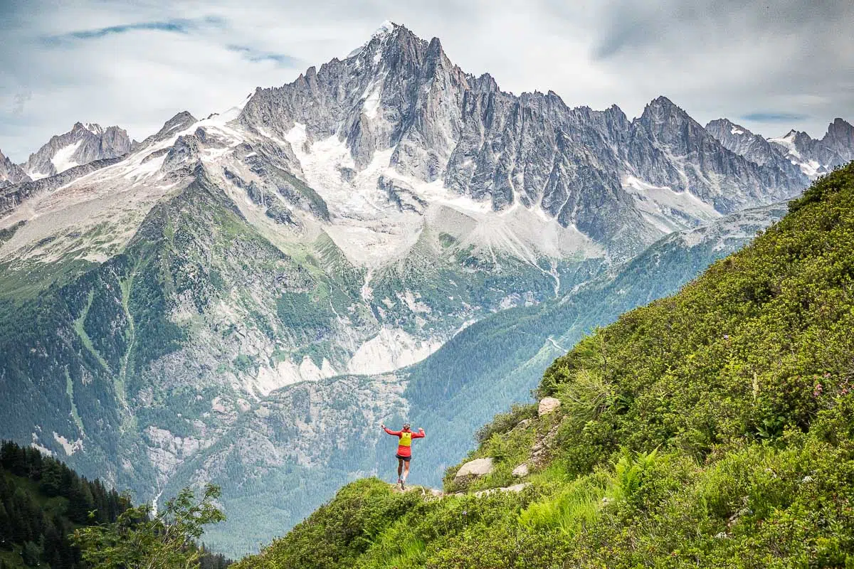 Traileur en pleine ascension d'un sentier de montagne au lever du jour