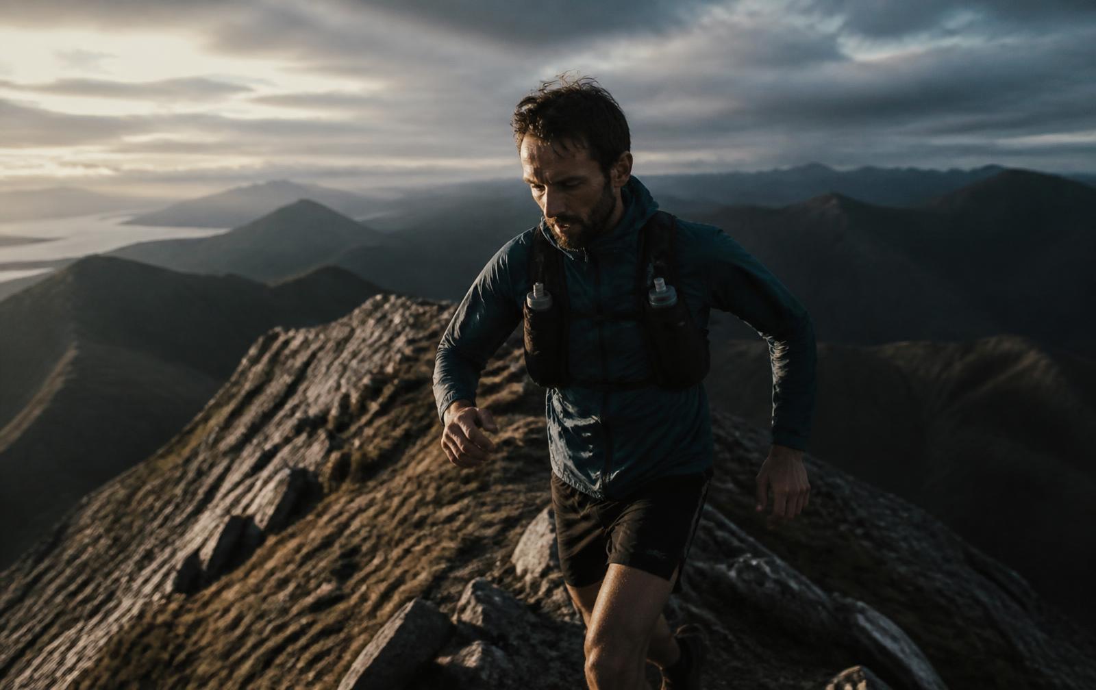 Coureur de trail sur une crête de montagne en fin de journée